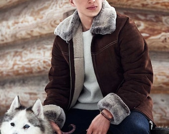 Puede incluir: Un hombre con una chaqueta de ante marrón con cuello y puños de piel se sienta con un perro husky blanco y gris. El hombre lleva un suéter blanco y pantalones vaqueros azules.