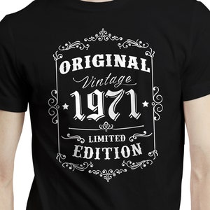 Peut inclure: T-shirt noir avec un motif blanc portant l'inscription "ORIGINAL Vintage 1971 LIMITED EDITION" dans un cadre décoratif. Le t-shirt est à manches courtes et semble être en coton.