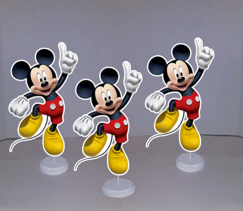 May include: Three Mickey Mouse centerpieces, each featuring a cartoon image of Mickey Mouse in a red and yellow outfit, with a white base.