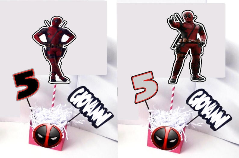 May include: Two pink boxes with a Deadpool character design. Each box has a white paper shred filler.  One box has a black number 5 and a black and white 'GIOVANNI' sign. The other box has a gray number 5 and a black and white 'GIOVANNI' sign. Both boxes have a Deadpool character on a stick.