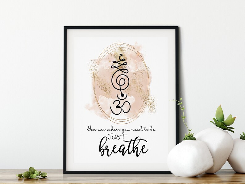 May include: A printable wall art print with a pink watercolor background and gold glitter. The print features a black and white Om symbol and the text "You are where you need to be JUST breathe".
