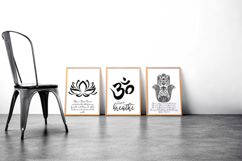 May include: Three framed prints with black and white designs. The first print features a lotus flower with the text "Take a deep breath, release what no longer serves you, and trust in the unfolding of life. From the mud blossom of the lotus." The second print features the Om symbol with the text "Just breathe." The third print features a hamsa hand with the text "Let our mindfulness come to the forefront. Let us be grateful for the blessings we have. Let us be confident in the knowing that we are safe and full with the unwavering light of our soul's presence."