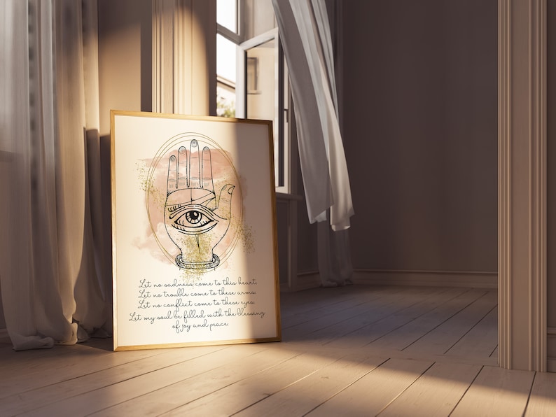 以下が含まれることがあります： 手のひらに目が描かれたハ​​ムサの手の水彩画プリント。プリントは金色のグリッター効果があり、"Let no sadness come to this heart, Let no trouble come to these arms, Let no conflict come to these eyes, Let my soul be filled with the blessing of joy and peace."というテキストが含まれています。