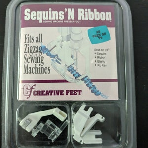May include: A white plastic sewing machine presser foot for sewing sequins, ribbon, elastic, and rickrack. The packaging says "Sequins'N Ribbon" and "Fits all Zigzag Sewing Machines".