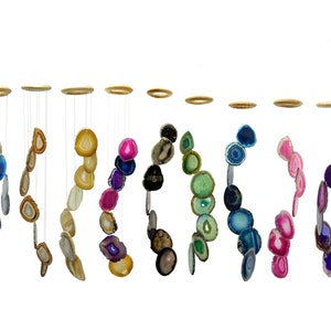May include: A set of 10 agate wind chimes, each with a different color and pattern. The chimes are made of natural agate slices and are suspended from a wooden ring. The agate slices are in shades of blue, green, pink, purple, and brown.