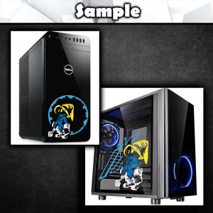K&ouml;nnte beinhalten: Schwarzer Computerturm mit Dell-Logo und einem Aufkleber mit einer Cartoonfigur. Der Aufkleber zeigt eine blau-gelbe Figur in einem blauen Kreis. Ein zweites Computergeh&auml;use mit einer Glasseitenwand ist ebenfalls abgebildet.