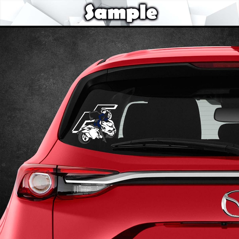 May include: A red car with a white decal of a person riding a motorcycle on the back window. The decal is in the shape of the letter F.