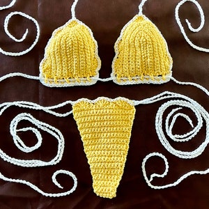 May include: A crocheted bikini set in yellow with white trim. The top is a triangle style and the bottom is a cheeky style.