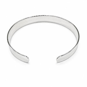 May include: A polished silver-tone cuff bracelet with a smooth, reflective surface and an open-ended design. The bracelet features a simple, rounded band that curves into a circular shape, showcasing a clean and uniform metallic finish throughout.