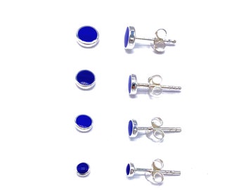 Op de afbeelding: Vier paar zilveren oorbel studs met ronde blauwe stenen. De oorbellen worden getoond in verschillende maten.
