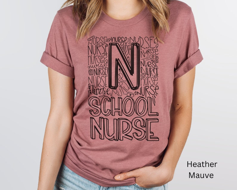 May include: A heather mauve t-shirt with a black graphic design that says "School Nurse" with the letter "N" made up of the word "Nurse" repeated multiple times.