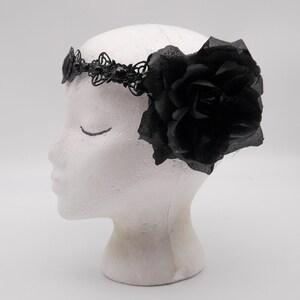 May include: Black headband with a large black rose and delicate lace detailing.