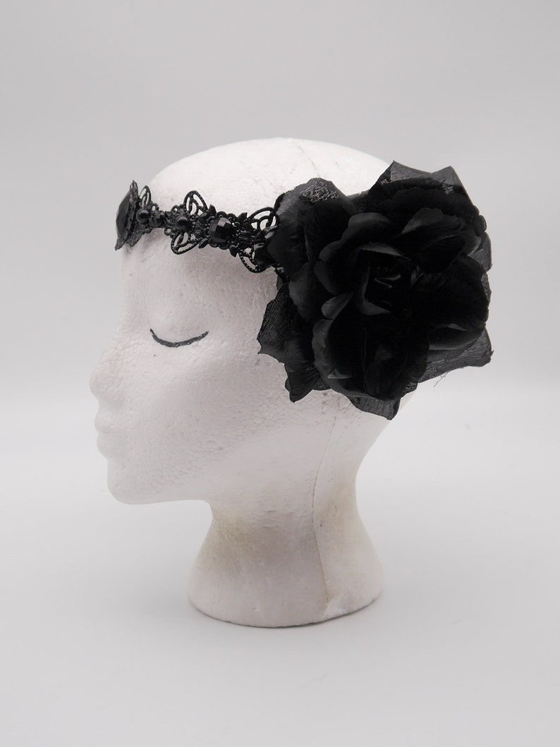 May include: Black headband with a large black rose and delicate lace detailing.