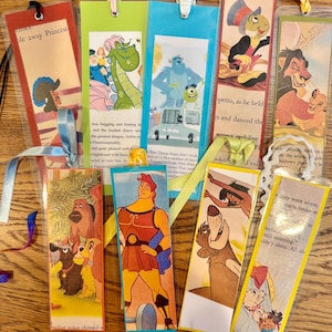 May include: A collection of colorful bookmarks featuring various cartoon characters from popular Disney movies. The bookmarks are made of cardstock and have a clear plastic coating. The characters include Hercules, Simba, Mushu, and others.