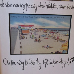 May include: A framed photo with a handwritten message that reads "We were naming the day when Wildwood came in view. On the way to Cape May, I fell in love with you!" The photo shows a vintage postcard of a beach scene with people and umbrellas.