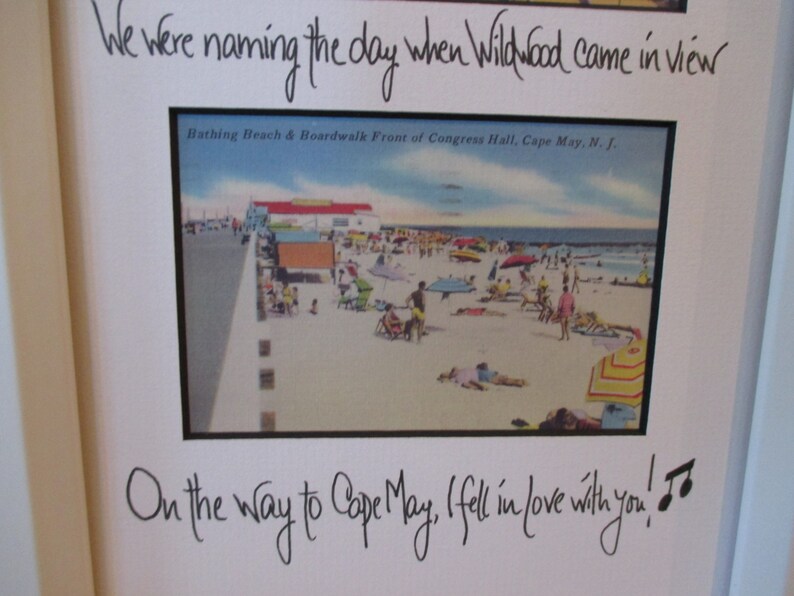 May include: A framed photo with a handwritten message that reads "We were naming the day when Wildwood came in view. On the way to Cape May, I fell in love with you!" The photo shows a vintage postcard of a beach scene with people and umbrellas.