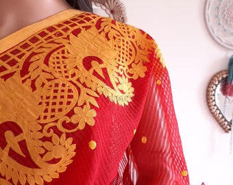 May include: Red sheer saree with gold embroidery featuring a floral design. The saree has a yellow border and small gold dots throughout.