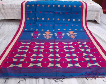 May include: A vibrant blue textile with a floral and geometric pattern. The fabric features a repeating design of pink and cream-colored shapes, with orange and pink floral accents. The border is a contrasting pink and cream stripe.