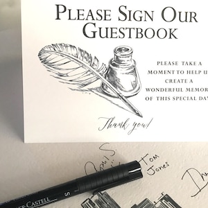 May include: A white rectangular sign with black text reading Please Sign Our Guestbook, followed by a black and white ink illustration of a quill and inkwell, and text reading Please take a moment to help us create a wonderful memory of this special day. Thank you!