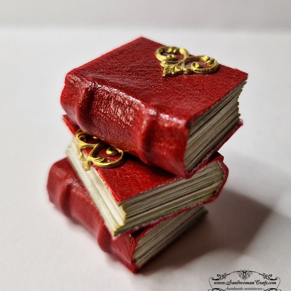 Miniature leather book. Red aged leather, decorated with brass, round spine, two raised bands. Paper non-openable pages Dollhouse miniatures