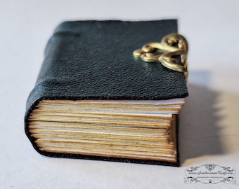 Miniature leather book. Dark green aged faux leather, decorated with brass, round spine, two raised bands-Paper non-openable pages-Dollhouse
