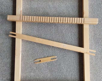 May include: A wooden loom with a shuttle and a heddle bar. The loom is made of natural wood and has a simple design.