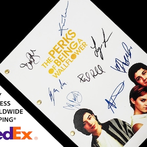 May include: A white script with the title "The Perks of Being a Wallflower" in gold lettering. The script is signed by the cast members, including Emma Watson, Logan Lerman, and Ezra Miller.