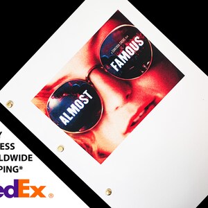 Puede incluir: Un póster con un primer plano de un rostro con gafas de sol. Las gafas de sol tienen las palabras "ALMOST FAMOUS" impresas. El póster es blanco con detalles en negro y tiene ojales dorados.