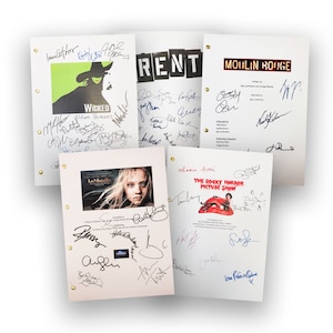Puede incluir: Una colección de guiones teatrales, incluyendo "Wicked", "Rent", "Moulin Rouge", "Les Misérables" y "The Rocky Horror Picture Show". Cada guion es blanco con texto negro y firmas. "Wicked" tiene un gráfico verde y negro.