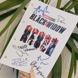 May include: A white script page from the Marvel Studios film "Black Widow" with signatures from the cast members: Scarlett Johansson, Florence Pugh, David Harbour, and Olga Kurylenko.