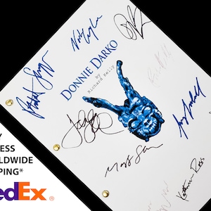 Puede incluir: Un guion blanco con el título "Donnie Darko" de Richard Kelly. El guion está firmado por varias personas, incluidos los actores Jake Gyllenhaal, Jena Malone y Katharine Ross.