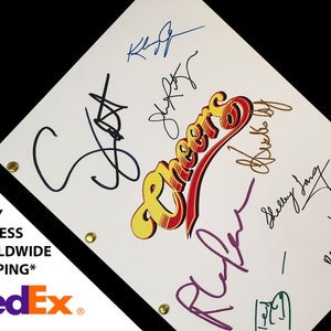 Könnte beinhalten: Ein weißes Skript mit dem Wort "Cheers" in einem gelben, roten und blauen Logo. Das Skript ist von der Besetzung der Fernsehsendung "Cheers" signiert, darunter Ted Danson, Shelley Long, Kirstie Alley und andere.