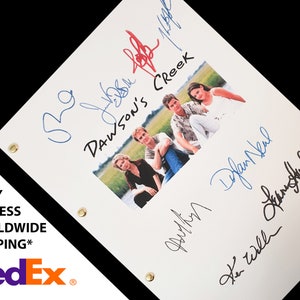 Può includere: Uno script bianco con il titolo "Dawson's Creek" e una foto di quattro persone. Lo script è firmato dalle quattro persone in inchiostro blu.