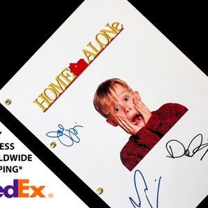 May include: A white script with the title "Home Alone" in yellow letters with a red house icon. A photo of Macaulay Culkin as Kevin McCallister from the movie Home Alone is in the center of the script. The script is signed by three people in blue ink.