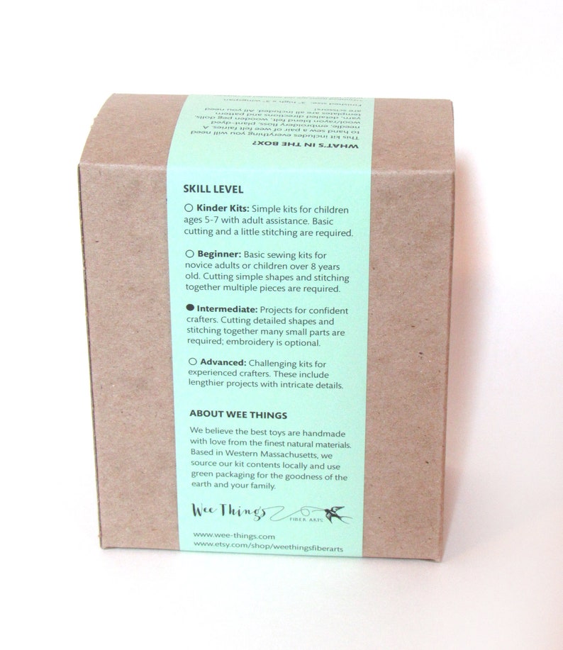 May include: A rectangular brown cardboard box featuring a light green paper band wrapped around it. The band contains printed text detailing skill levels, including Kinder, Beginner, Intermediate, and Advanced, along with company information.