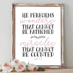 May include: A white framed print with a black and pink inspirational quote that reads "He performs wonders that cannot be fathomed miracles that cannot be counted Job 5:9".