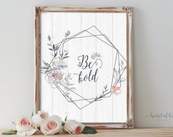 May include: A white framed print with a geometric design and watercolor flowers. The print features the text "Be bold" in black.