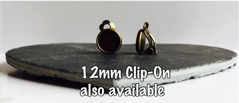 May include: Two gold-toned clip-on earring findings with a 12mm round setting. 12mm Clip-On also available.