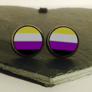 May include: A pair of gold-toned stud earrings with a yellow, white, purple, and black flag design.