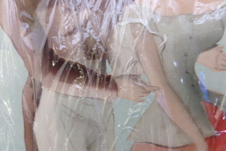 May include: Two women wearing white dresses with lace trim. The dresses are sheer and the women's bodies are visible through the fabric. The women are standing close together and their arms are wrapped around each other.
