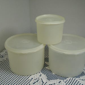 May include: A set of three ceramic vases in varying heights and shapes. The vases are glazed in a matte white finish, offering a minimalist aesthetic. The tallest vase is approximately 10 inches high.