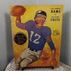 Puede incluir: Un programa de fútbol americano vintage de los Los Angeles Rams del 12 de diciembre de 1959, con una foto de un jugador con una camiseta azul con el número 12. El programa es para un partido contra los Baltimore Colts y cuesta 25 centavos. El partido se jugó en el Los Angeles Memorial Coliseum.