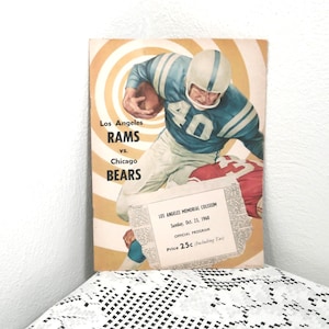 Può includere: Copertina del programma di calcio vintage Los Angeles Rams contro Chicago Bears. L'immagine presenta un giocatore in uniforme blu e bianca. Il programma include il testo "Los Angeles Rams vs. Chicago Bears" e "Los Angeles Memorial Coliseum, Sunday, Oct. 23, 1960."