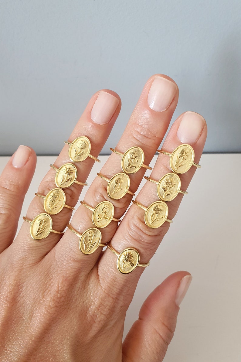 Pu&ograve; includere: Un set di 12 anelli in oro con diversi design floreali. Ogni anello presenta un motivo floreale unico, creando un look delicato e femminile.