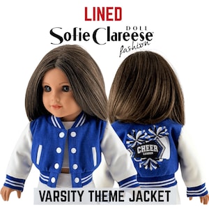 May include: A doll wearing a blue and white varsity theme jacket with white snap buttons and striped cuffs. The back of the jacket features an embroidered graphic of pom-poms and the text CHEER LEADER. The text LINED and Sofie Clareese Doll Fashion are visible.