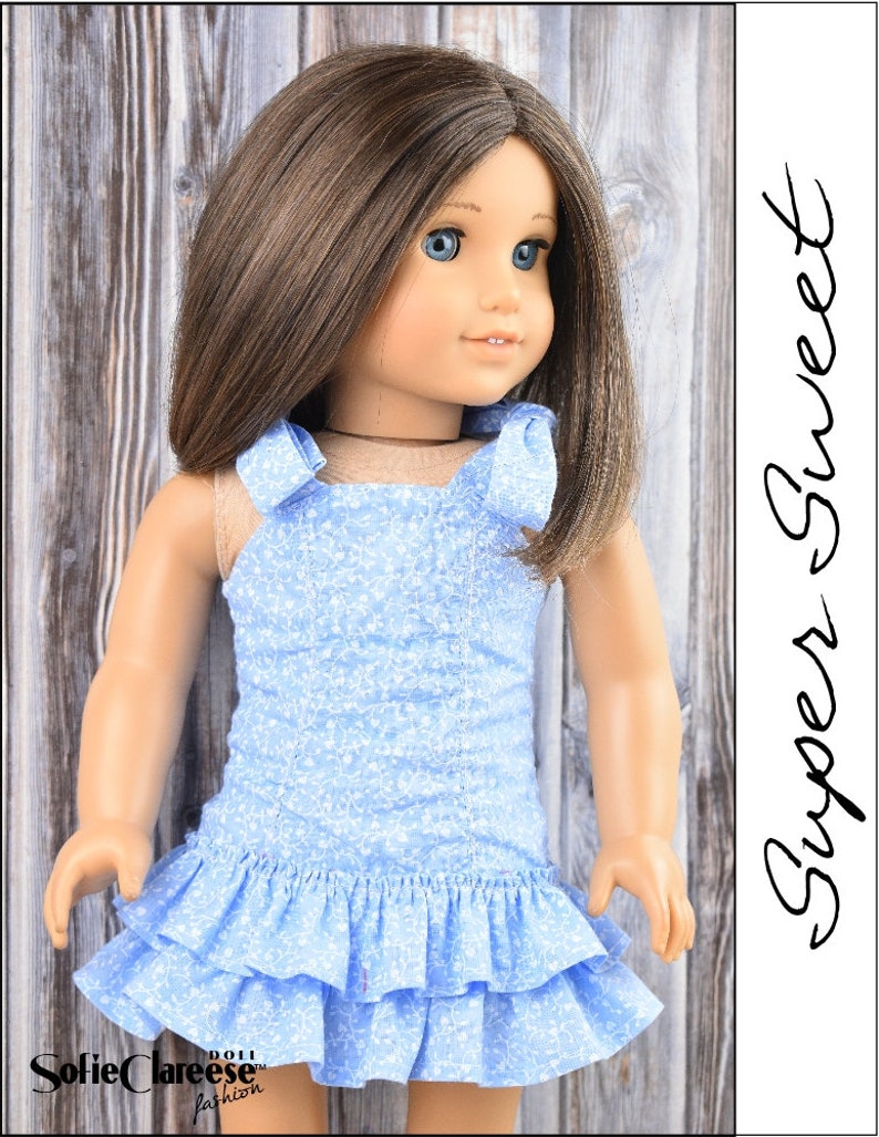 May include: A blue and white floral print dress with a ruffled hem. The dress has a halter style neckline with two bows on the straps. The dress is designed for a doll.