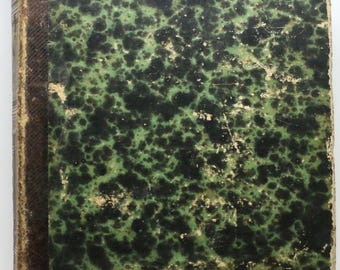 Op de afbeelding: Een oud boek met een gevlekte groen-zwarte kaft. De kaft heeft een gespikkeld patroon en vertoont tekenen van slijtage. De rug is donkerbruin van kleur.