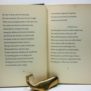 May include: A vintage book with a cream-colored cover and black text. The book is open to pages 6 and 7. The text on the left page reads "By some of them, and sent afoot again For new encounters. Fear was a breath of night, When met by strangling doubt of what there was For certain to be feared. Let him know that, And let him be a stranger once again Among the millions, far from the old shadow, And far from the old house. Let him be told An answer to that one unanswered question, And let the frenzied endless elements, That gave him power to make of honest men His honorable slaves, take him again To their mysterious workshop and remould him To something good or to no thing at all, And let him then be dead. For he was tired Of dying, he was tired of being so strong As to be still alive and as a thing", and the text on the right page reads "Contrariously composed of opposites Too firm to be deceived or reconciled; And he was not yet told. At last he rose And through the moonlit window looked away Over still trees between him and a cliff That ended his domain as death ends life. There was no answer there, but still he looked As if to find one. He was colder now, And shivered as he turned again to see Where moonlight filled a desolated hearth, So many a time alive with fire that once Had hummed a comfortable song of home, Which was a word that he might find in books, By looking for it. There were new silences".