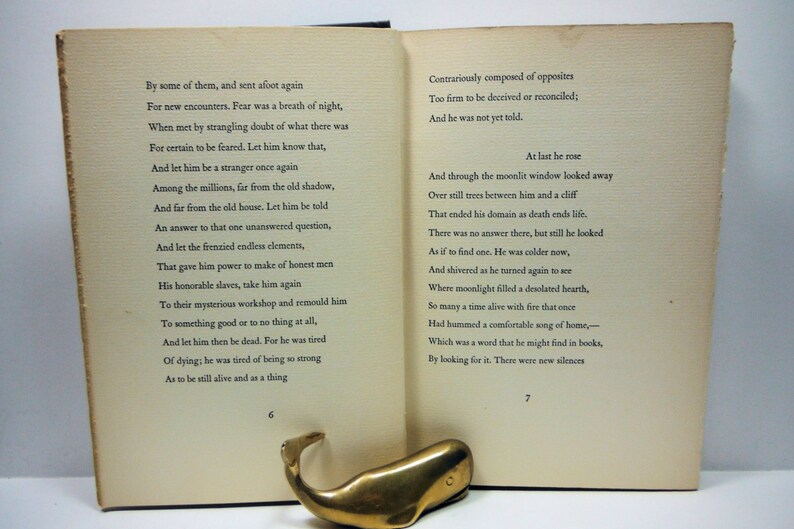 May include: A vintage book with a cream-colored cover and black text. The book is open to pages 6 and 7. The text on the left page reads "By some of them, and sent afoot again For new encounters. Fear was a breath of night, When met by strangling doubt of what there was For certain to be feared. Let him know that, And let him be a stranger once again Among the millions, far from the old shadow, And far from the old house. Let him be told An answer to that one unanswered question, And let the frenzied endless elements, That gave him power to make of honest men His honorable slaves, take him again To their mysterious workshop and remould him To something good or to no thing at all, And let him then be dead. For he was tired Of dying, he was tired of being so strong As to be still alive and as a thing", and the text on the right page reads "Contrariously composed of opposites Too firm to be deceived or reconciled; And he was not yet told. At last he rose And through the moonlit window looked away Over still trees between him and a cliff That ended his domain as death ends life. There was no answer there, but still he looked As if to find one. He was colder now, And shivered as he turned again to see Where moonlight filled a desolated hearth, So many a time alive with fire that once Had hummed a comfortable song of home, Which was a word that he might find in books, By looking for it. There were new silences".