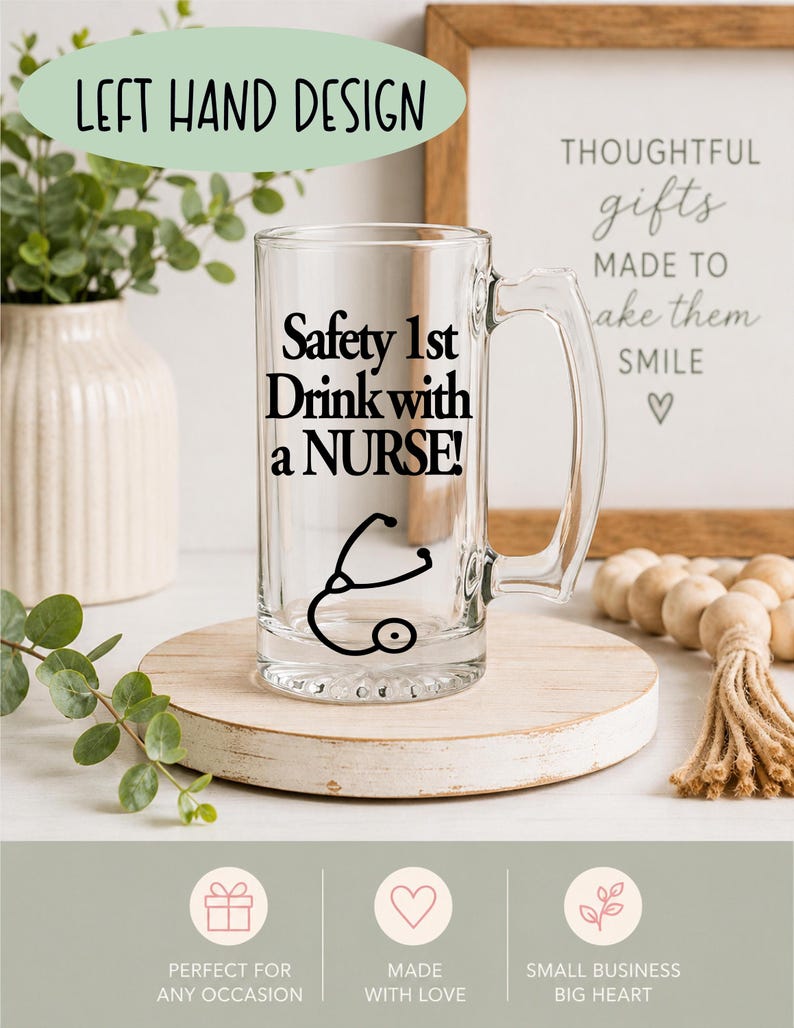 May include: A clear glass beer mug with a handle, featuring the text "Safety 1st Drink with a NURSE!" in black, along with a stethoscope graphic. The mug is displayed on a wooden coaster, with decorative elements in the background.